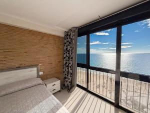 a bedroom with a bed and a large window with the ocean at Apartamentos Colón - Grupo Antonio Perles in Calpe +13 photos