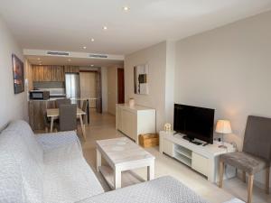 a living room with a couch and a tv at Apartamentos Colón - Grupo Antonio Perles in Calpe