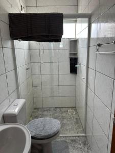 een badkamer met een douche, toilet en wastafel bij Hyago Monteiro in Capão da Canoa +18 foto's
