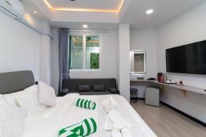a bedroom with a white bed and a flat screen tv at Sunway Ukulhas in Ukulhas