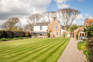 a large lawn in front of a house at Caiplie Farmhouse, Caiplie, by Crail, KY10 3JR in Kilrenny
