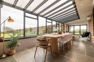 a dining room with a table and some windows at Caiplie Farmhouse, Caiplie, by Crail, KY10 3JR in Kilrenny