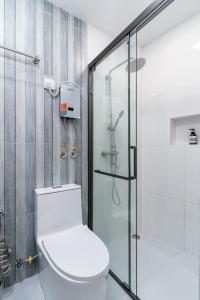 a bathroom with a toilet and a glass shower at Sunway Ukulhas in Ukulhas +1 photo