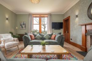 a living room with a couch and a table at Caiplie Farmhouse, Caiplie, by Crail, KY10 3JR in Kilrenny
