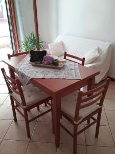 a wooden table with two chairs and a couch at Appartamento ai Tigli in Noale