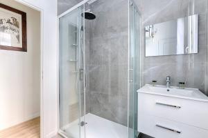 a bathroom with a glass shower and a sink at Appartement de charme à Boulogne in Boulogne-Billancourt