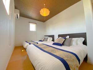 two beds in a room with white walls at OKINAWA POOLWILLA ONNA 4A / Vacation STAY 70971 in Baba +35 photos