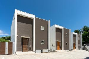 a large building with four doors in a parking lot at OKINAWA POOLWILLA ONNA 4A / Vacation STAY 70971 in Baba