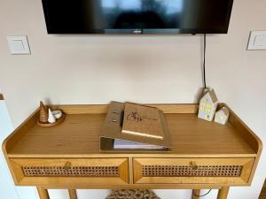 a wooden table with a tv on top of it at Le Nichoir de la Colline - Parking & Wifi in Obernai