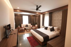 a bedroom with a bed and a living room at Anasvara Hotels in Mysore +34 photos