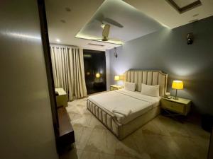 Un dormitorio con una cama y dos lámparas y una ventana. en DHA Elite Suits, en Lahore