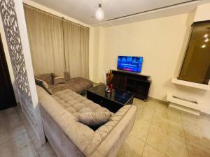 a living room with two couches and a flat screen tv at DHA Elite Suits in Lahore +2 photos