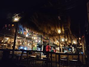 a restaurant with a bar with people sitting at it at night at Wanagiri Campsite in Gitgit