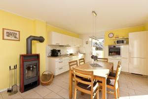 a kitchen with a table and a wood stove at Kiebitz in Röbel