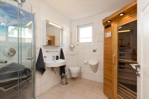 a bathroom with a toilet and a sink and a shower at Kiebitz in Röbel +13 photos