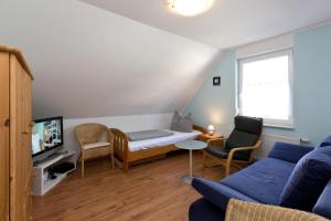 a living room with a blue couch and a tv at Kiebitz in Röbel