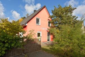 a red house with a fence in front of it at Kiebitz in Röbel