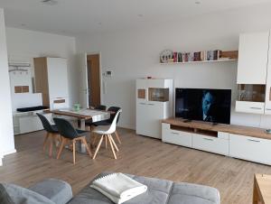 een keuken en een woonkamer met een tafel en een televisie bij Seerose in Malchow