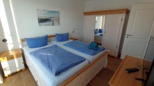 een slaapkamer met een groot bed met blauwe kussens bij Seerose in Malchow