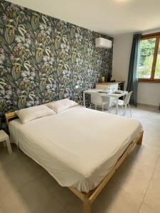1 dormitorio con 1 cama grande y papel pintado con motivos florales en The Green Nest - pool & lake view, en Costermano