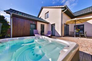 a hot tub in the backyard of a house at Green Eagle Lodge in Lebbin