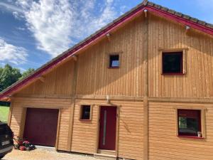 a large wooden building with two garage doors at Chalet du hérisson in Ménétrux-en-Joux