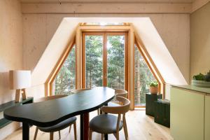 a room with a table and chairs and a large window at Il Pino in Tarvisio