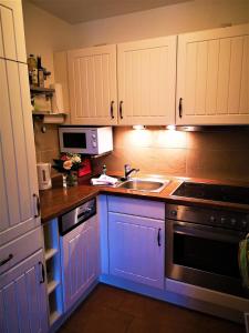 a kitchen with white cabinets and a sink at Weitblick in Lebbin +10 photos