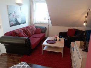 a living room with a red couch and a table at Golf Oase in Lebbin