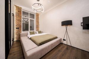 ein Schlafzimmer mit einem Bett und einer Lampe in der Unterkunft Rynok Square Pidzemelya in Lwiw