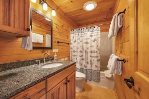 un bagno con lavandino e servizi igienici in una baita di tronchi di Straight From The Heart a Wahkiacus Altre 37 foto