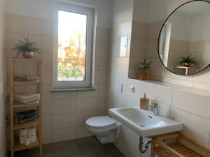 a bathroom with a toilet and a sink and a mirror at Am Hafen 15 in Röbel +13 photos