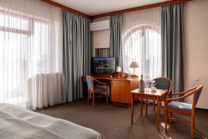 a hotel room with a desk and a bed at April hotel Panorama in Rychnov nad Kněžnou