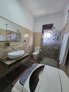 a bathroom with a shower and a sink and a toilet at Villa Bloomscape in Galle