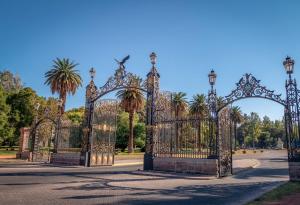 an ornate gate in a park with palm trees at El Estudio in Villa Marini +6 photos