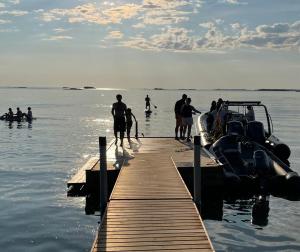 un grupo de personas de pie en un muelle en el agua en Forest View Cottage, 