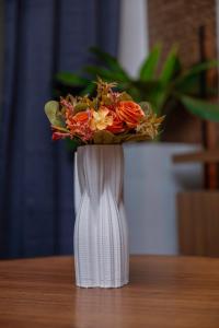 a white vase with a bouquet of flowers in it at Studio Spacieux et Moderne à Bietry in Abidjan