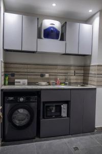 a kitchen with a washing machine and a microwave at Studio Spacieux et Moderne à Bietry in Abidjan +9 photos