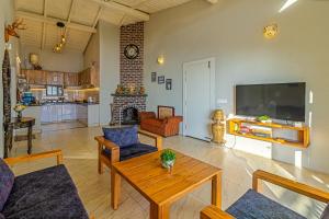 a living room with a table and a tv at Villa KAILASA in Mukteshwar