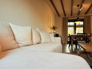 uma sala de estar com um sofá branco e uma mesa em Maison spacieuse avec jardin à Soignies em Soignies