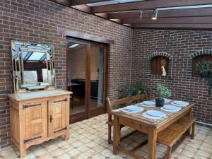um pátio com uma mesa de madeira e um espelho em Maison spacieuse avec jardin à Soignies em Soignies mais 21 fotografias
