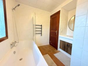 um banheiro com uma banheira branca e uma pia em Maison spacieuse avec jardin à Soignies em Soignies