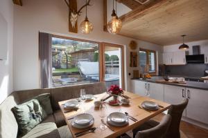 una sala da pranzo con un tavolo e una cucina di das brunn - Luxus Chalet a Kirchberg in Tirol