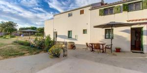 a patio with a table and an umbrella in front of a building at Tia in Veli Lošinj