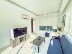 een woonkamer met een blauwe bank en een tafel bij Alassia Blue Villa in Protaras