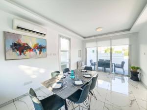 een eetkamer met een tafel en stoelen bij Alassia Blue Villa in Protaras