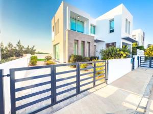 een wit huis met een hek bij Alassia Blue Villa in Protaras