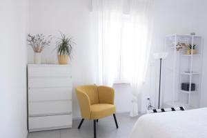ein Schlafzimmer mit einem gelben Stuhl und einer Kommode in der Unterkunft Rosmaris - Villa nel verde in Francavilla al Mare