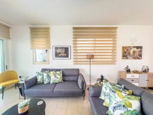 a living room with two couches and a table at Villa Allegra in Protaras