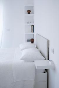 ein Schlafzimmer mit einem weißen Bett und einem Waschbecken in der Unterkunft Rosmaris - Villa nel verde in Francavilla al Mare